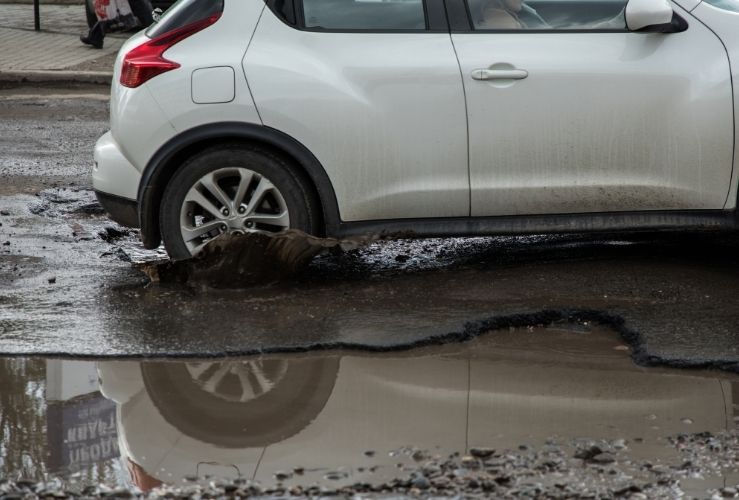 A car sinking into a pothole