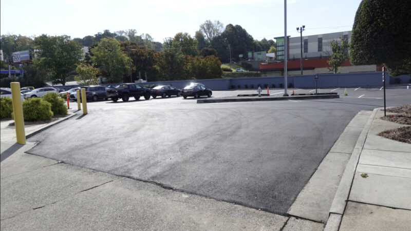 A parking lot is pictured with cars parked