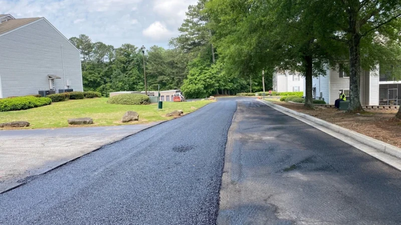 Half of a road can be seen with fresh asphalt.